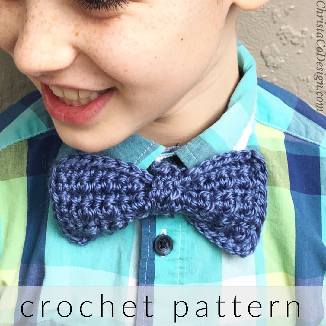 Boy smiling wearing blue plaid and blue crochet bow tie.