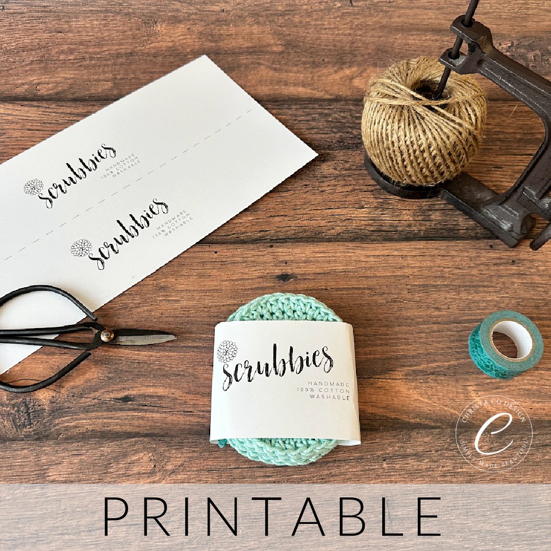 Mint round crochet scrubbies wrapped in paper label surrounded by notions.
