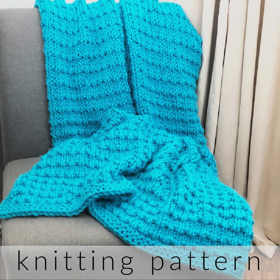 Bright blue textured knit blanket on grey chair.