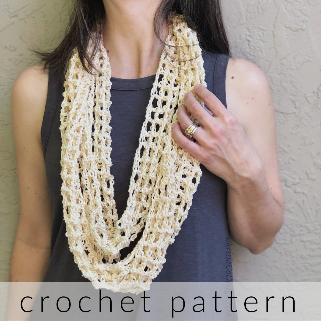 Woman with cream infinity scarf looped around neck.