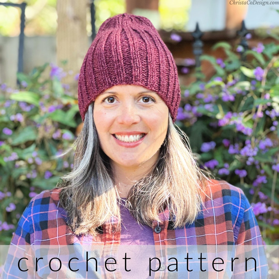 Woman in maroon ribbed beanie smiling.