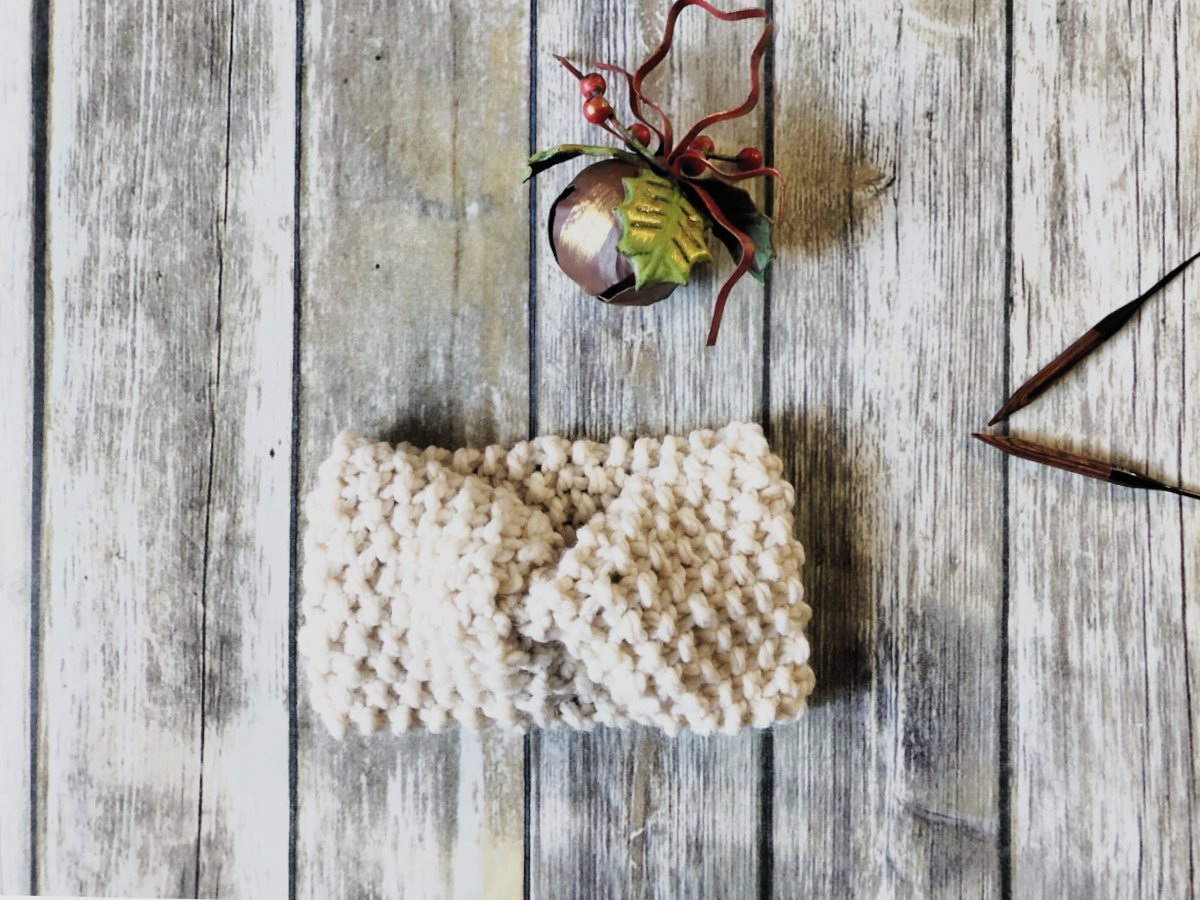 Knit earwarmer with bell and needles.