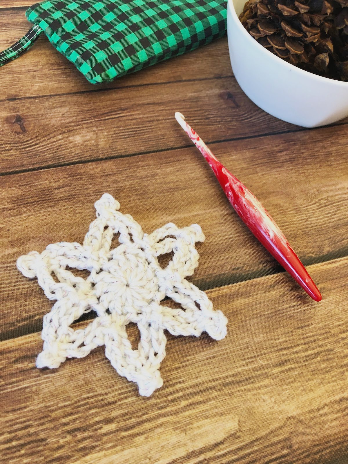 Angled view of crochet snowflake in glitter yarn.