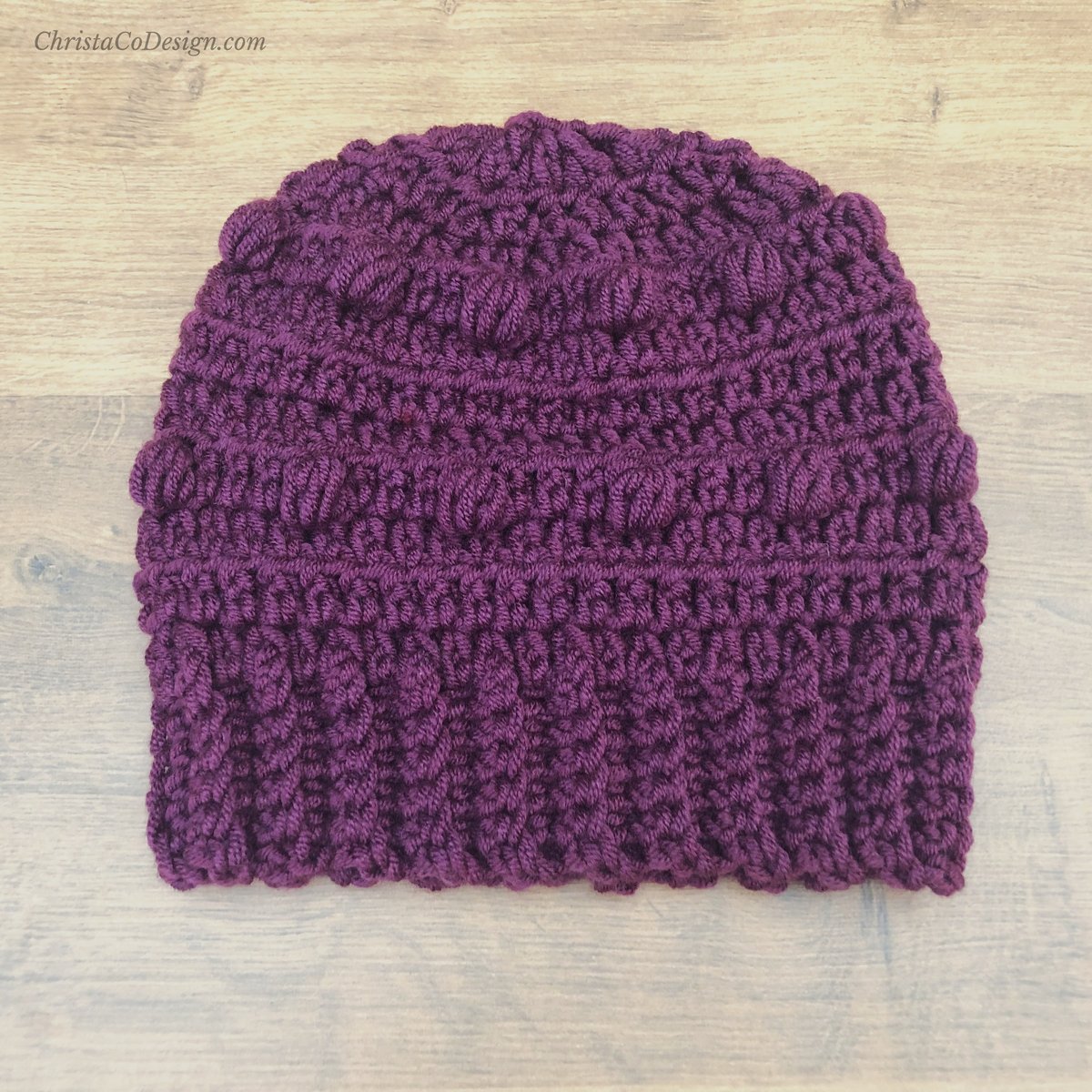 Slouchy crochet hat with bobbles in purple.