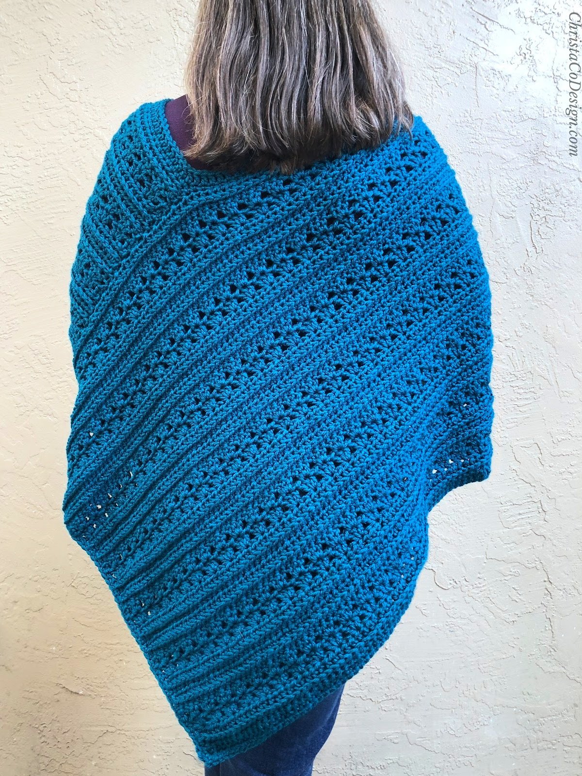 Back of woman in blue crochet poncho.