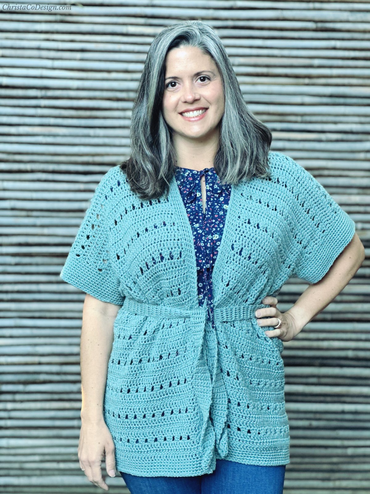 Woman in green crochet cardigan with belt.