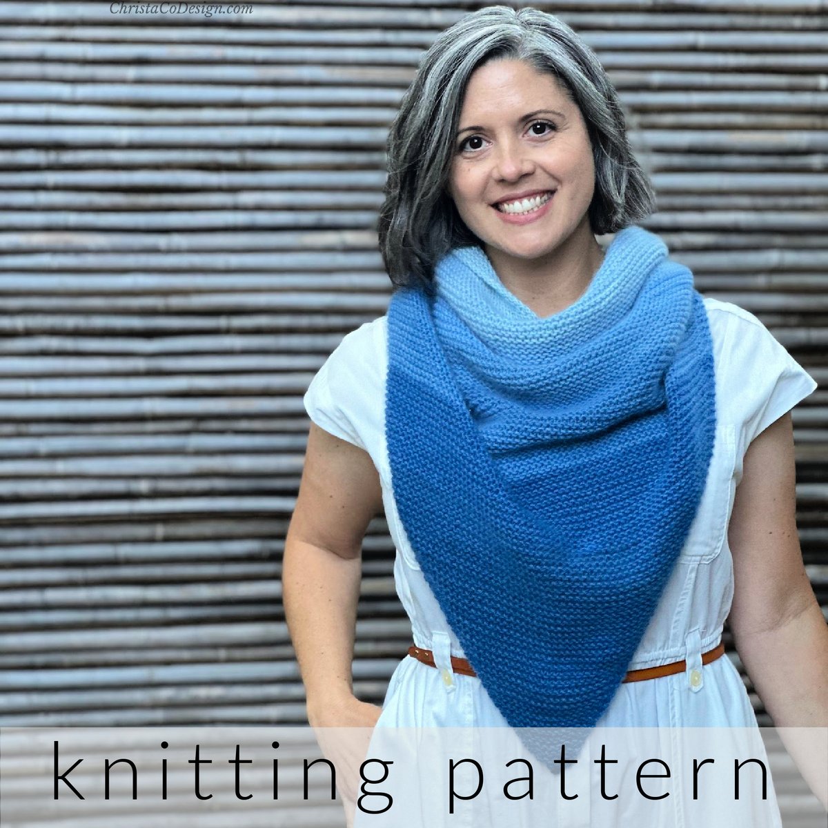 Woman smiling with blue ombre knit shawl draped over neck.
