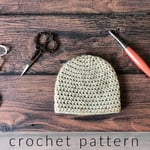 Cream half double crochet beanie with scissors and peach hook.