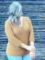 Woman with arms crossed to show 3/4 length sleeves on crochet sweater.