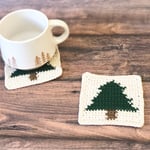 Coffee mug on crochet christmas tree coaster next to another.
