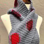Mannequin with grey scarf with red circles wrapped on neck.