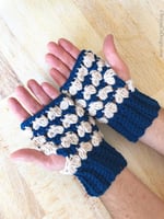 Mens hands open to show cream and navy crochet fingerless gloves.