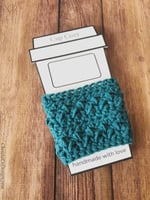Blue crochet cup cozy sleeve on white cup printed on paper.