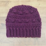 Slouchy crochet hat with bobbles in purple.