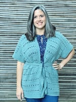 Woman in green crochet cardigan with belt.