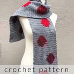 Grey crochet scarf with red dots on mannequin.