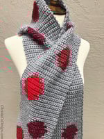 Grey scarf with red dots wrapped on mannequin.