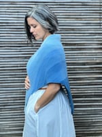 Woman turned to the side to show ombre of triangle knit shawl.