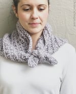 Woman looking down with purple knit neck tie.