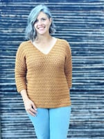 Woman smiling in crochet sweater with v-neck.