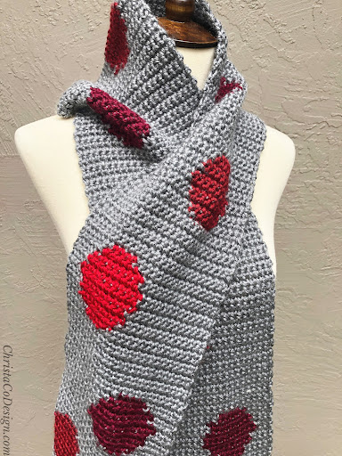 Grey scarf with red dots wrapped on mannequin.