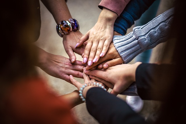 Hands in a circle that form a team.