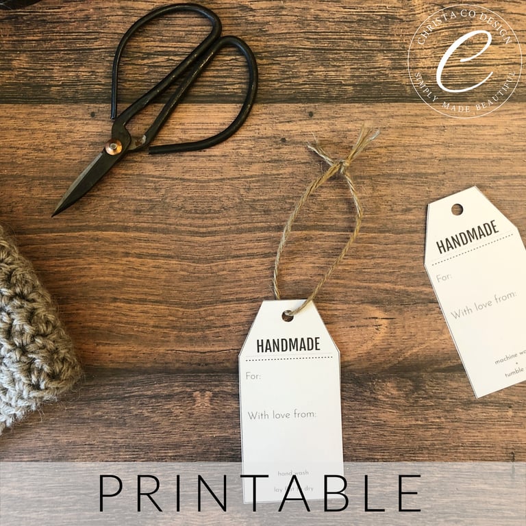 White gift tags with handmade on it next to scissors.