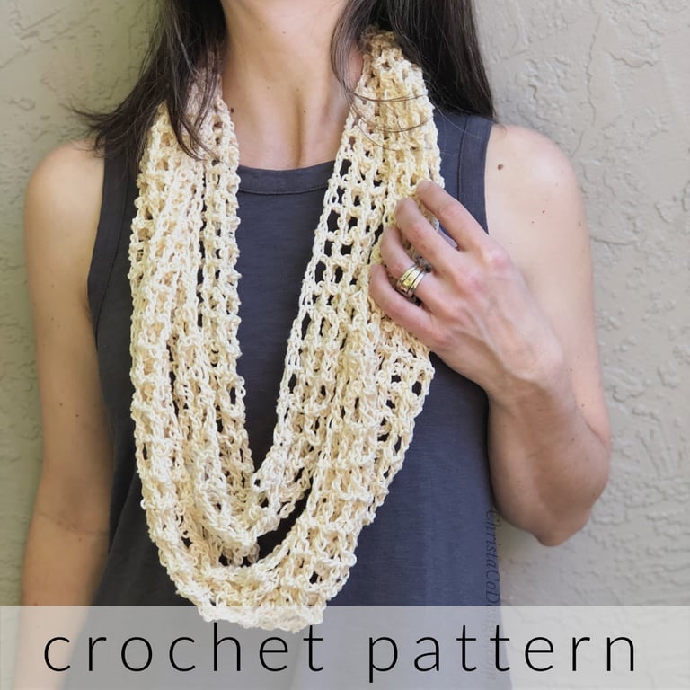 Woman with cream infinity scarf looped around neck.